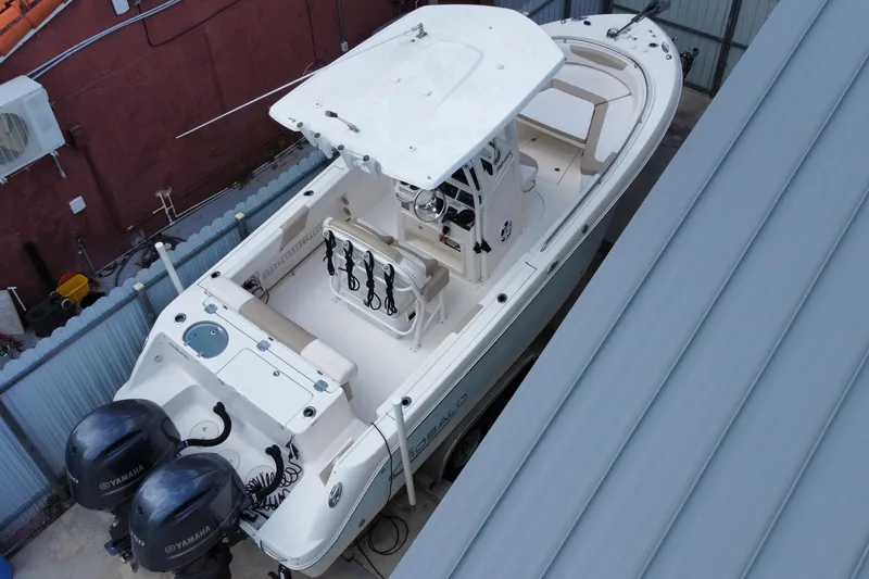 Slide: The Image of 2018 Robalo R242 Center Console boat with dual Yamaha engines, docked in a sheltered area. - 27