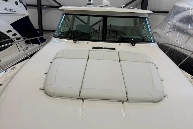 Slide: The Image of 2023 Tiara Yachts 43 Open with cushioned deck, docked indoors. - 1