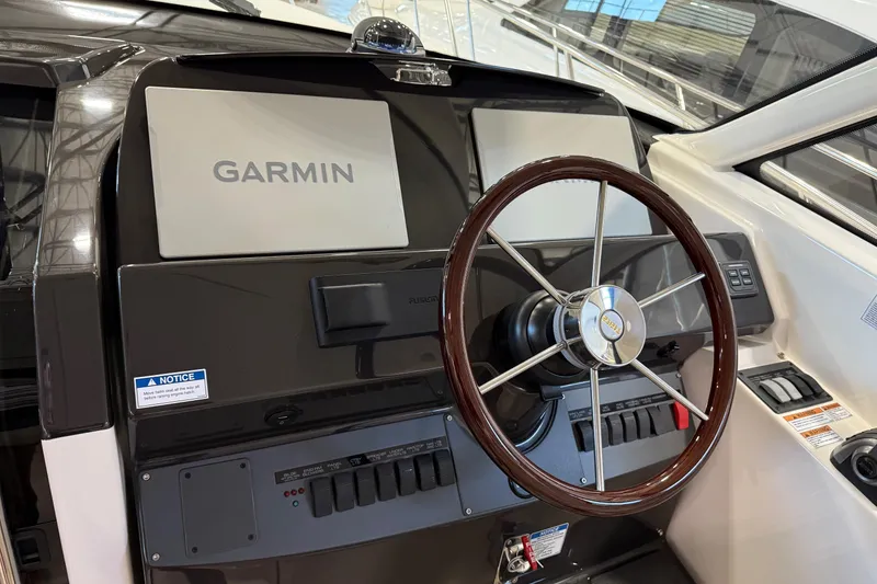 Slide: The Image of 2023 Tiara Yachts 43 Open helm with Garmin navigation system and wooden steering wheel. - 10