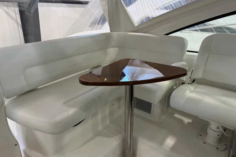 Slide: The Image of 2023 Tiara Yachts 43 Open interior with white seating and wooden table. - 12