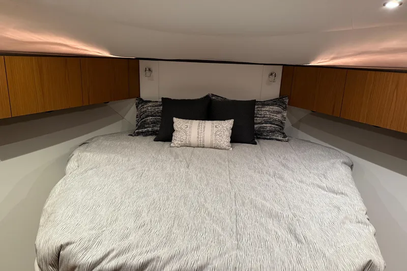 Slide: The Image of Luxurious bedroom interior of 2023 Tiara Yachts 43 Open, featuring elegant bedding and wood cabinetry. - 18