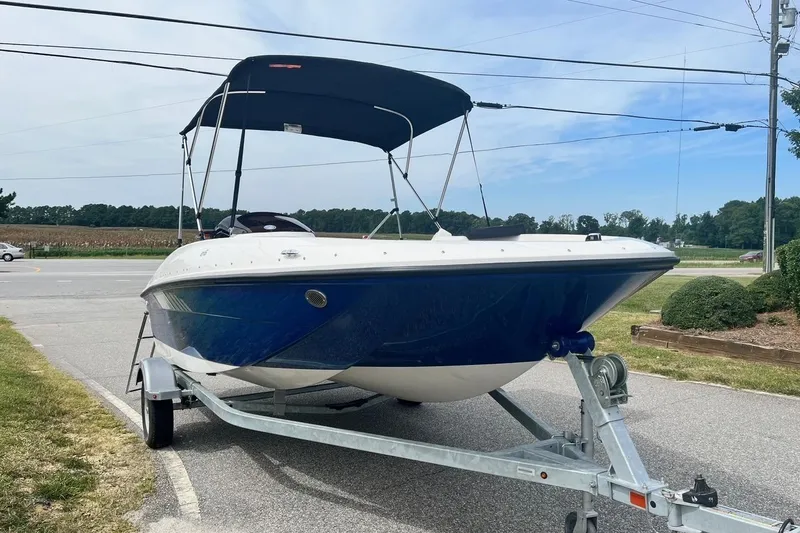 Slide: The Image of 2026 Bayliner Element E16 on trailer, blue hull, parked roadside. - 2