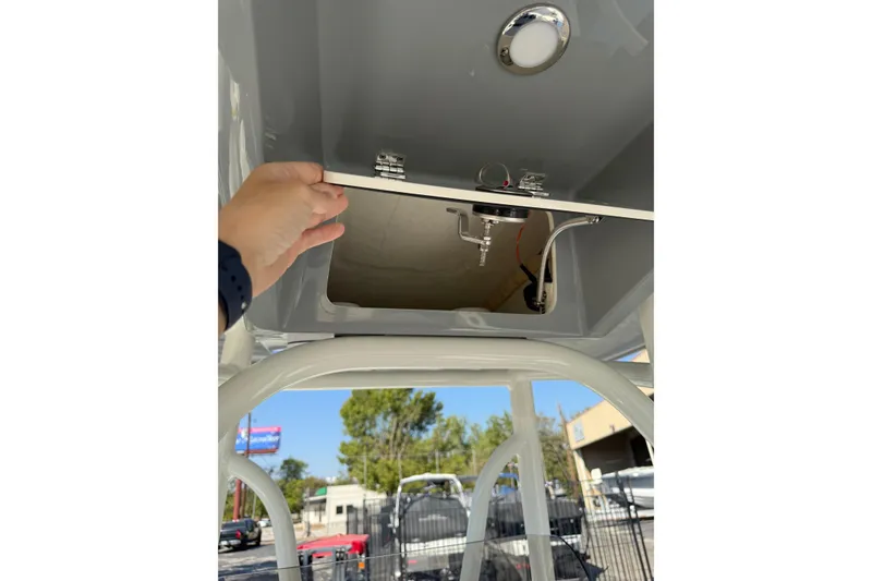 Slide: The Image of Hand opening compartment on 2026 Pathfinder 2400 Open boat, showing interior details. - 33