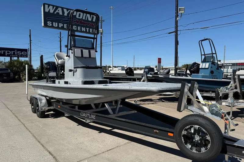 The Image of 2026 Freedom Boats 24 Defender on trailer at dealership, sunny day. - 0