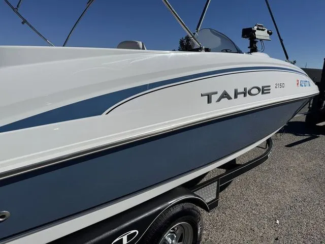 Slide: The Image of 2020 Tahoe 2150 boat on trailer, white and blue design, clear sky background. - 14