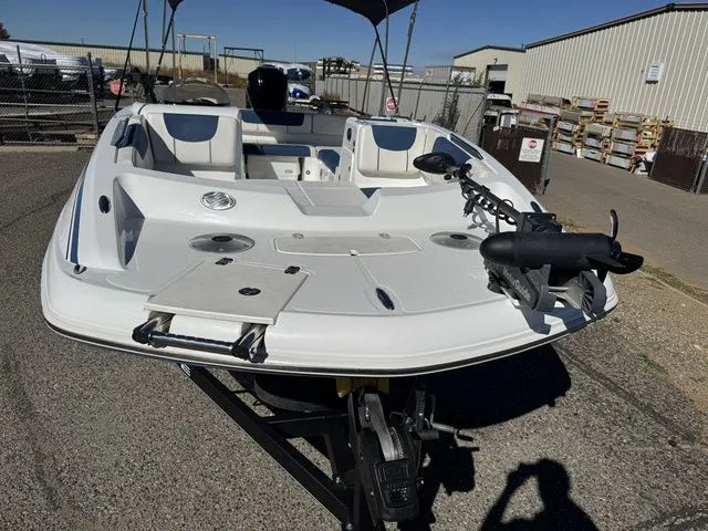 Slide: The Image of 2020 Tahoe 2150 boat on trailer, white exterior, parked outdoors near industrial buildings. - 16