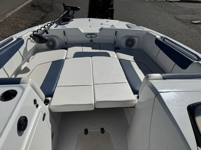 Slide: The Image of 2020 Tahoe 2150 boat interior with white and blue seating, featuring speakers and storage compartments. - 22