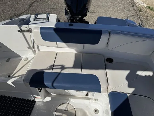 Slide: The Image of 2020 Tahoe 2150 boat interior with blue and white seating, featuring a motor and storage compartments. - 34