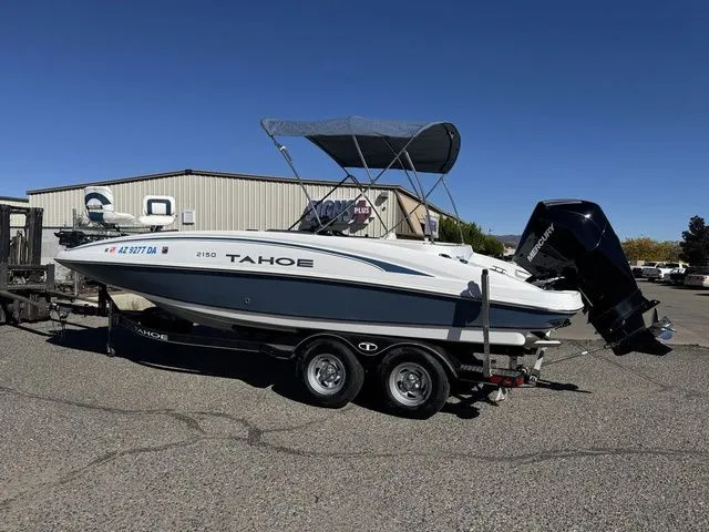 Slide: The Image of 2020 Tahoe 2150 boat on trailer with canopy, parked outdoors. - 41