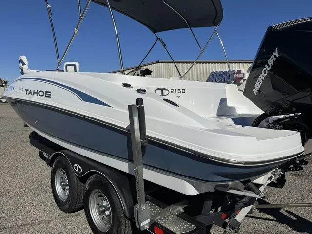 Slide: The Image of 2020 Tahoe 2150 boat on trailer with Mercury engine, parked outdoors. - 46