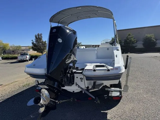 Slide: The Image of 2020 Tahoe 2150 boat with outboard motor, parked outdoors under clear sky. - 5