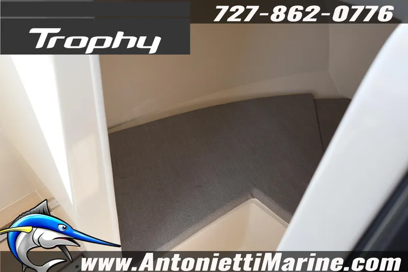 Slide: The Image of 2025 Trophy T 25 Pilothouse interior with cushioned seating, contact details, and website. - 13