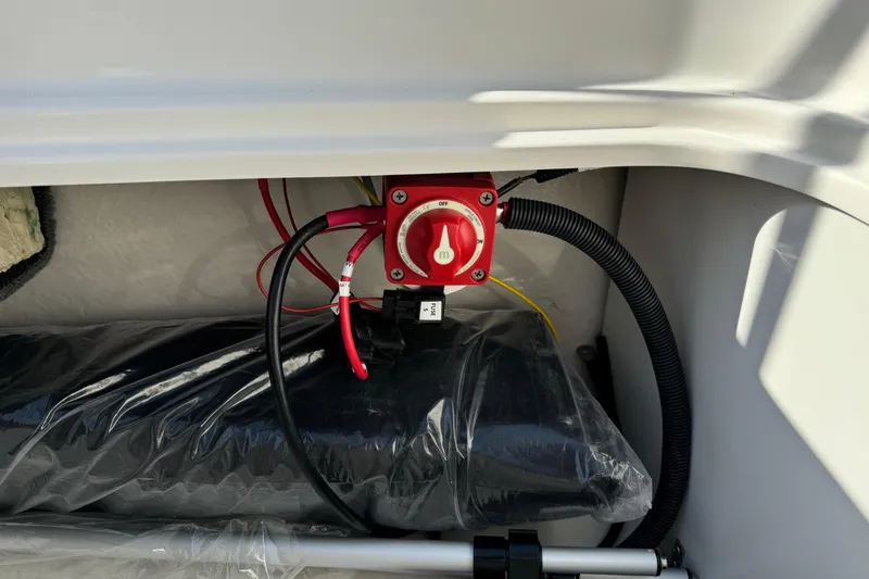 Slide: The Image of Battery switch and wiring inside 2025 Bayliner Element E16 boat compartment. - 17