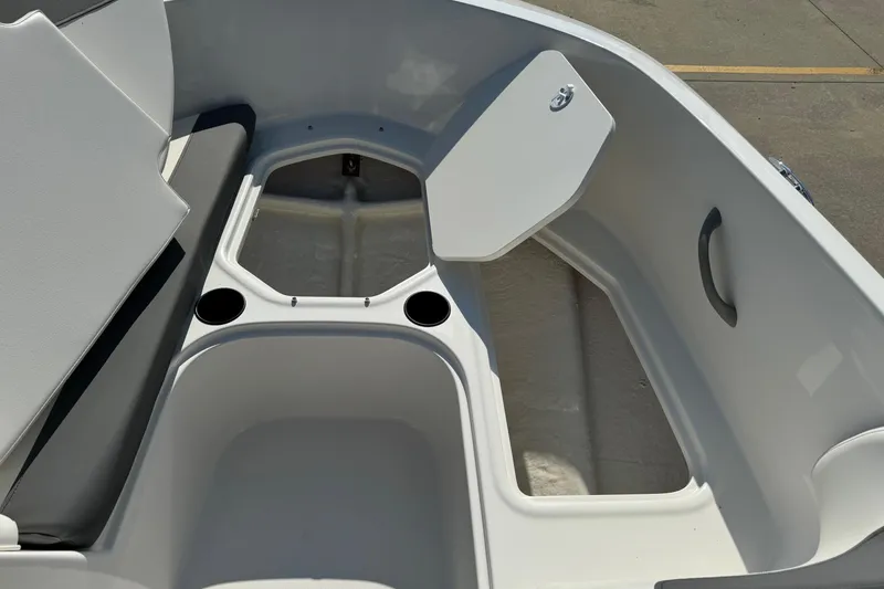 Slide: The Image of 2025 Bayliner Element E16 boat interior with open storage compartment and cup holders. - 7