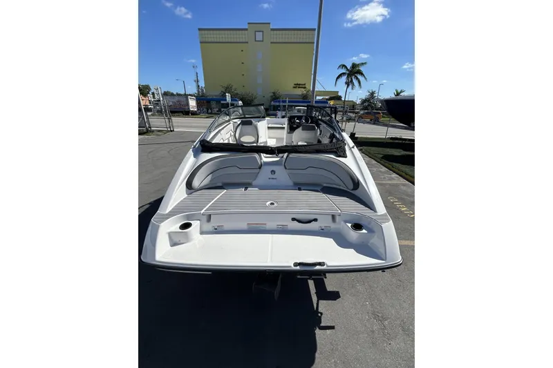 Slide: The Image of 2019 Yamaha Boats SX190, rear view, parked outdoors under clear blue sky. - 17