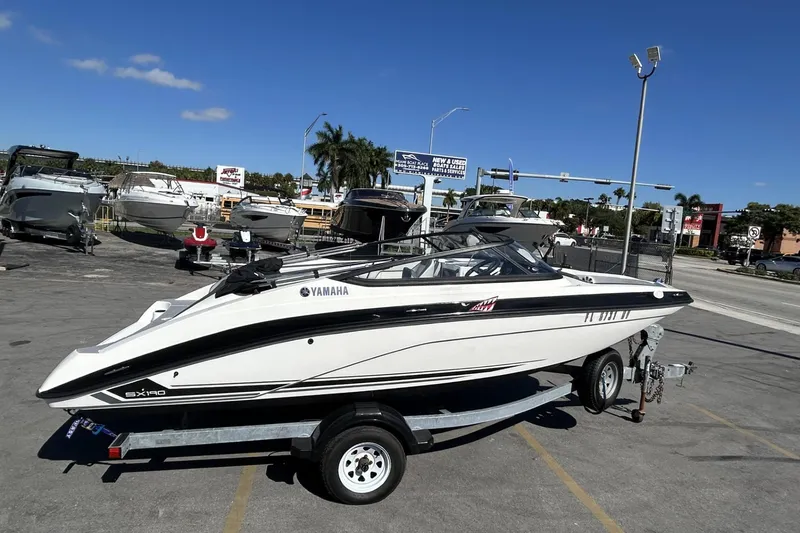Slide: The Image of 2019 Yamaha Boats SX190 on trailer in sunny outdoor dealership setting. - 18
