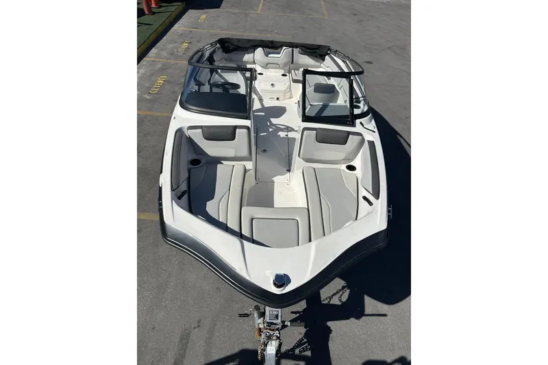 Slide: The Image of 2019 Yamaha Boats SX190, white and gray interior, parked on a trailer. - 23