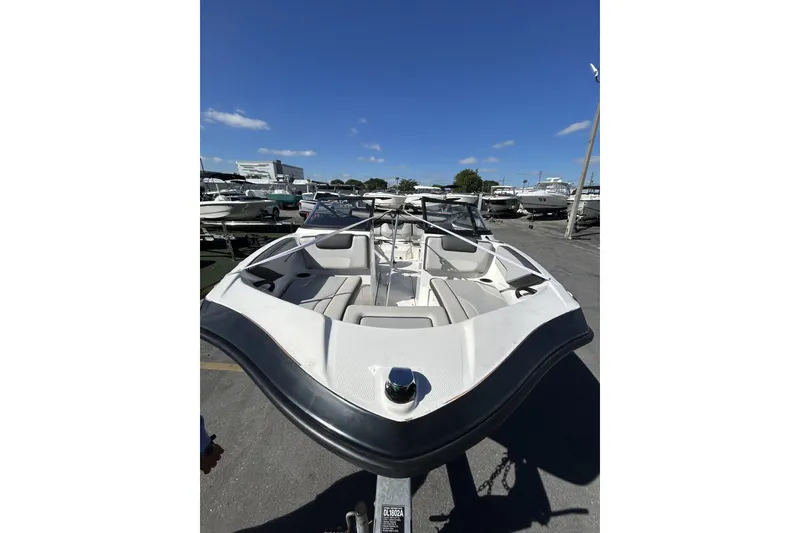 Slide: The Image of 2019 Yamaha Boats SX190, white interior, parked in a marina under a clear blue sky. - 3