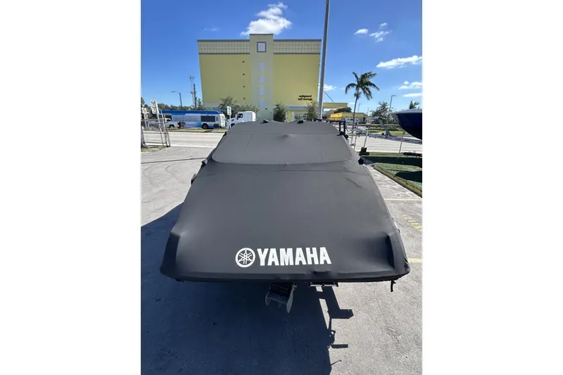 Slide: The Image of 2019 Yamaha Boats SX190 covered, parked outdoors under a clear blue sky. - 30
