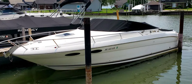Slide: The Image of 1996 Sea Ray 280 Sun Sport boat docked in a marina, covered with a black tarp. - 1