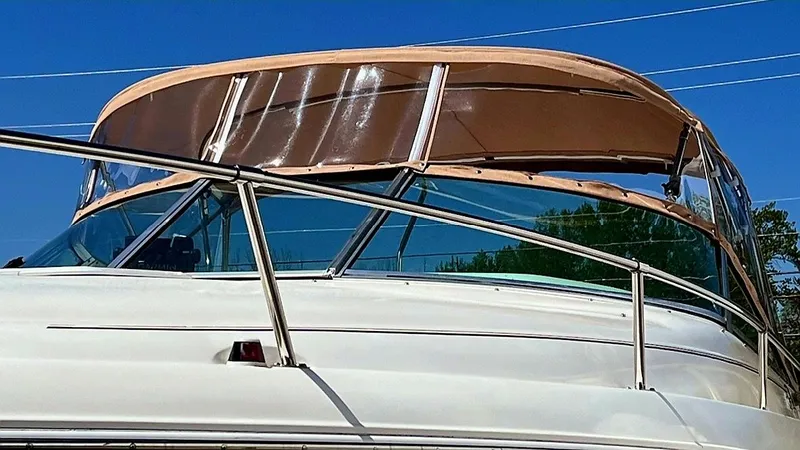 Slide: The Image of 1996 Sea Ray 280 Sun Sport boat with tan canopy and stainless steel railings. - 11