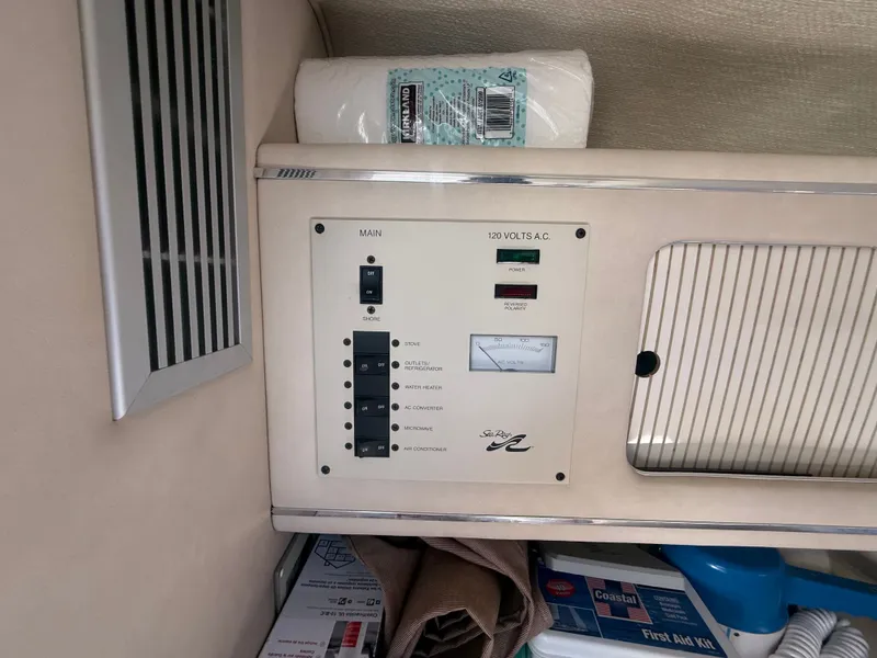 Slide: The Image of 1996 Sea Ray 280 Sun Sport electrical panel with switches and storage compartment. - 16