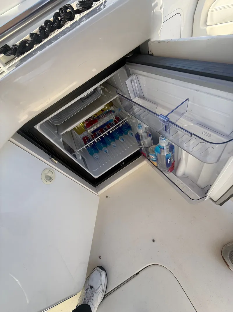 Slide: The Image of Open fridge on 1996 Sea Ray 280 Sun Sport boat, stocked with drinks and water bottles. - 19