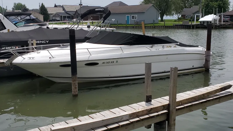 Slide: The Image of 1996 Sea Ray 280 Sun Sport boat docked in a marina, covered and ready for use. - 2