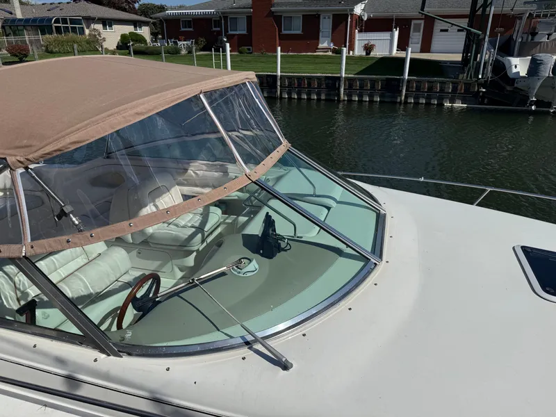 Slide: The Image of 1996 Sea Ray 280 Sun Sport boat with tan canopy docked by waterfront homes. - 7