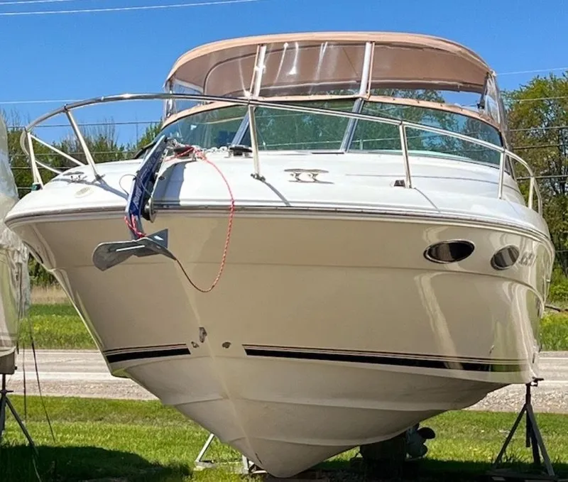 Slide: The Image of 1996 Sea Ray 280 Sun Sport boat on land, front view, clear sky background. - 9