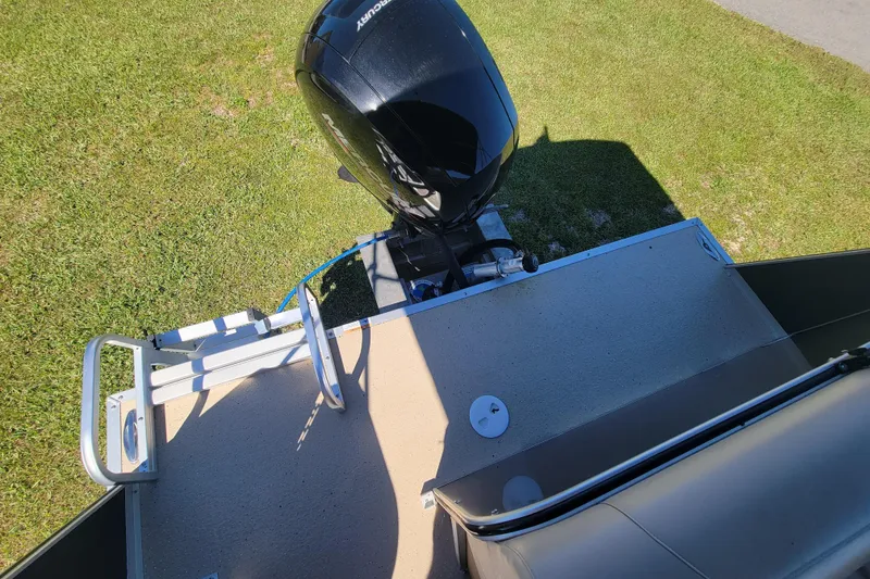 Slide: The Image of 2022 Fiesta Fundeck L Sofa RE Deluxe boat with outboard motor on grass. - 17