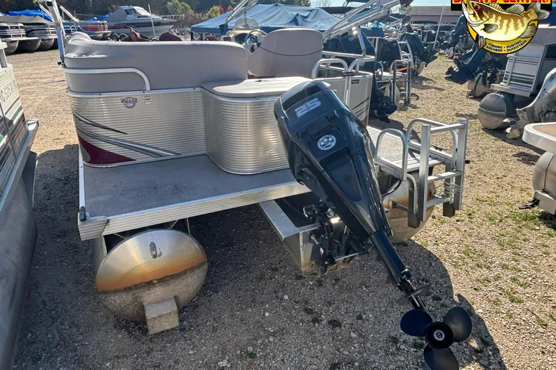 Slide: The Image of 2019 Qwest Edge 816 CR pontoon boat with outboard motor, parked on gravel. - 2