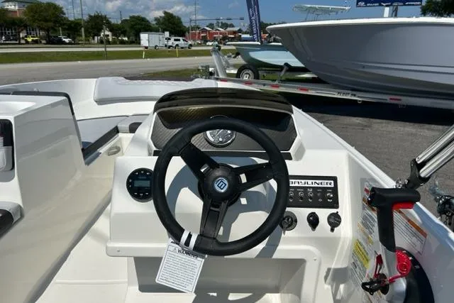 Slide: The Image of 2026 Bayliner M17 boat dashboard with steering wheel and control panel in a sunny outdoor setting. - 11