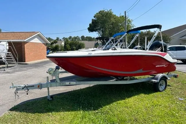 Slide: The Image of 2026 Bayliner M17 boat in red on a trailer, parked outdoors. - 2
