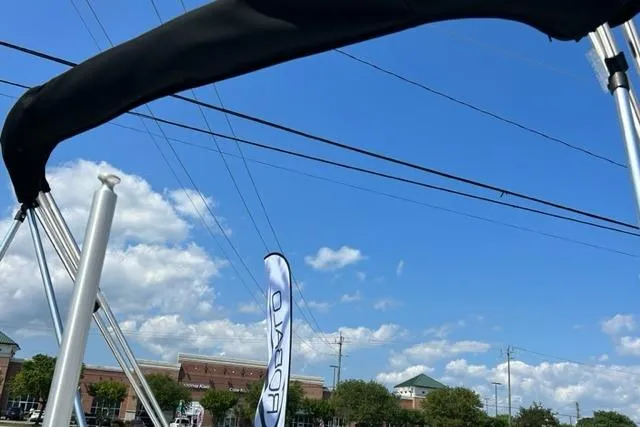 Slide: The Image of 2026 Bayliner M17 boat with canopy against blue sky and clouds. - 8