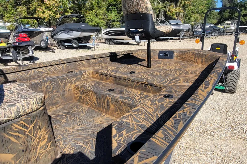 Slide: The Image of 2026 G3 Bay 21 GX Tunnel boat with camouflage design in a boatyard setting. - 11