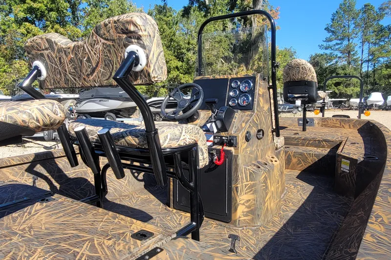Slide: The Image of 2026 G3 Bay 21 GX Tunnel boat with camo seats and console, parked outdoors. - 14