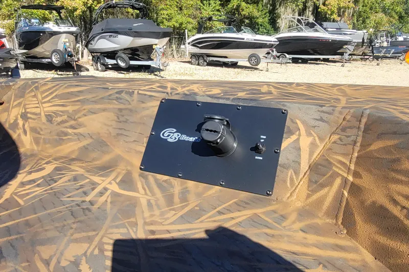 Slide: The Image of 2026 G3 Bay 21 GX Tunnel boat control panel with camouflage design in a boatyard. - 15