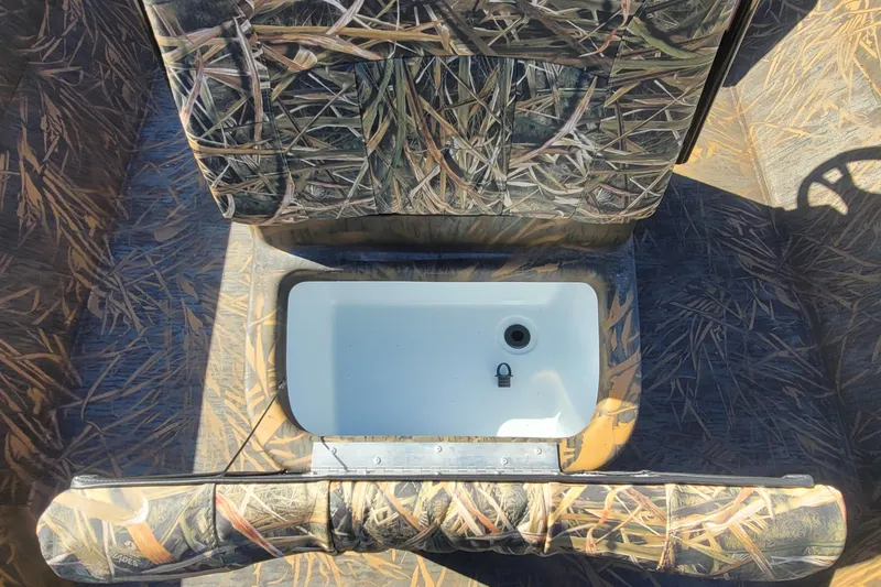 Slide: The Image of 2026 G3 Bay 21 GX Tunnel boat interior with camouflage seating and storage compartment. - 18