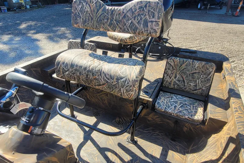 Slide: The Image of 2026 G3 Bay 21 GX Tunnel boat with camo seats and steering wheel. - 22