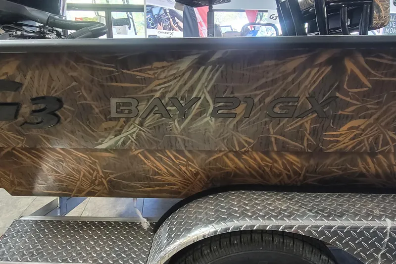 Slide: The Image of 2026 G3 Bay 21 GX Tunnel boat with camouflage design on a trailer. - 29