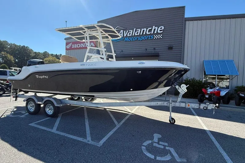 The Image of 2026 Bayliner Trophy T22CC boat on trailer at Avalanche Motorsports dealership. - 1