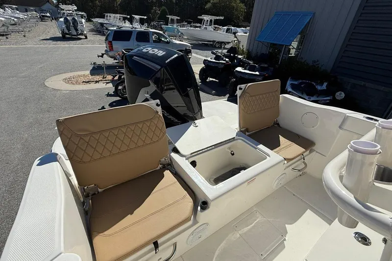Slide: The Image of 2026 Bayliner Trophy T22CC boat interior with tan seats and outboard motor. - 14