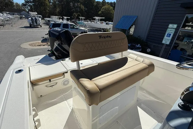 Slide: The Image of 2026 Bayliner Trophy T22CC boat interior with tan seating and Mercury outboard motor. - 15