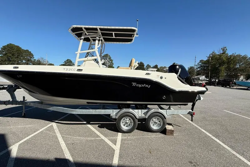 Slide: The Image of 2026 Bayliner Trophy T22CC boat on trailer in parking lot, clear sky background. - 3