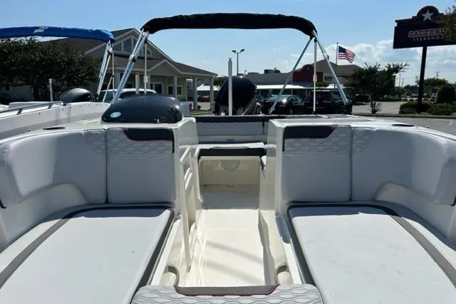 Slide: The Image of 2026 Bayliner M17 boat interior with seating and canopy, parked outdoors. - 14