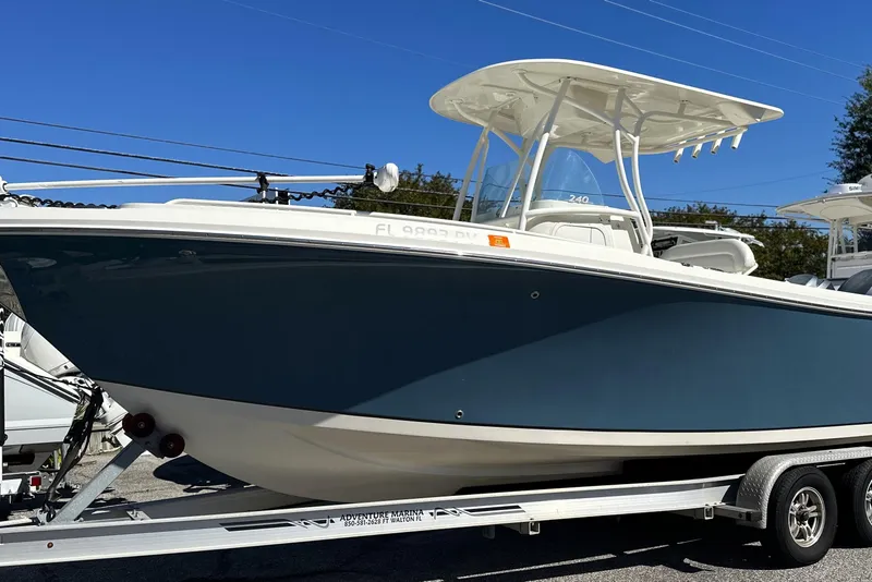 The Image of 2015 Sailfish 240 CC boat on trailer under clear blue sky. - 0