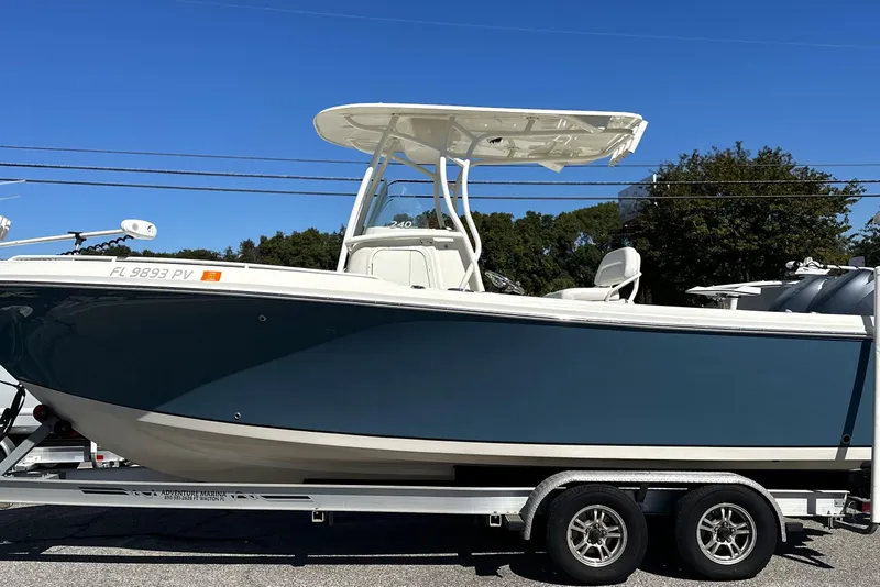 Slide: The Image of 2015 Sailfish 240 CC boat on trailer, side view, under clear blue sky. - 1
