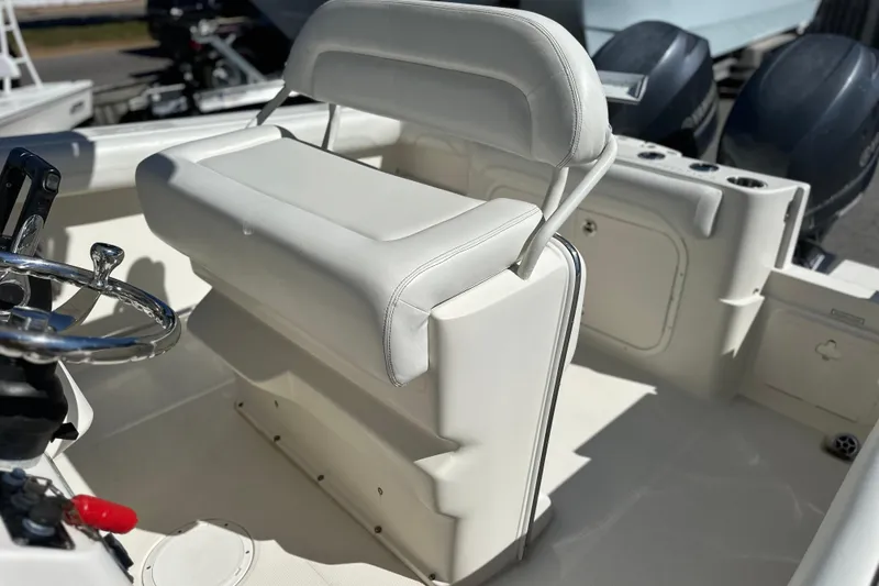 Slide: The Image of 2015 Sailfish 240 CC boat interior with white seating and steering wheel. - 2