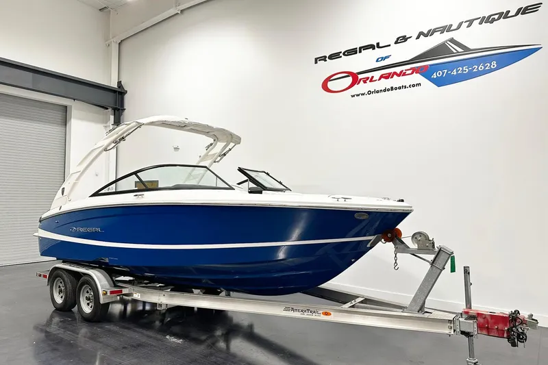 Slide: The Image of 2025 Regal LS2 boat on trailer in showroom, Orlando dealership. - 2